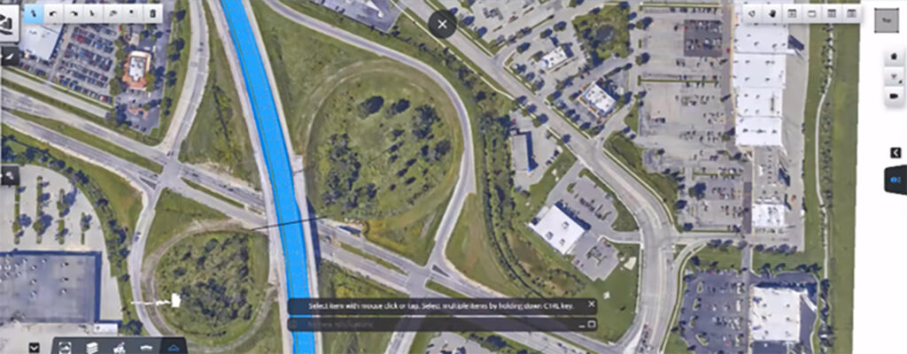 Aerial view of a highway interchange with looping ramps, a blue-highlighted waterway, adjacent roads, buildings, and green spaces. Screenshot highlights Civil Infrastructure elements within a multidiscipline design mapping tool interface.
