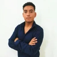 A person stands with arms crossed, wearing a dark blue shirt, like one might wear for a day on the roads, against a plain white background.